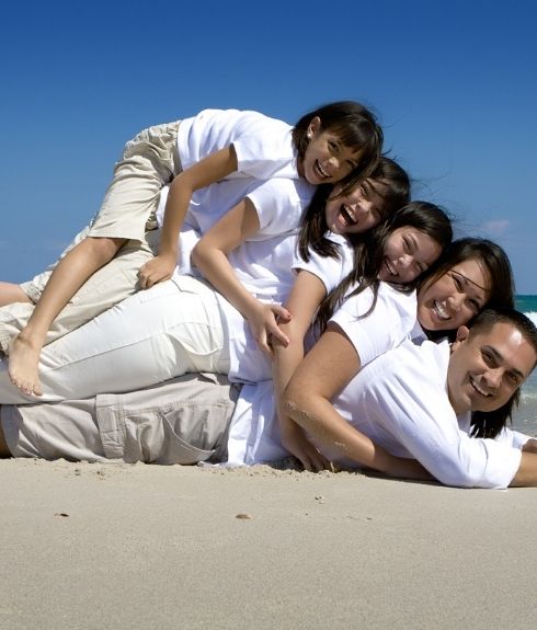 hispanic family on the beach in a pyramid smiling at camera hispanic family on the beach in a pyramid smiling at camera