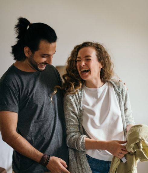 young mixed race couple cooking and drinking wine