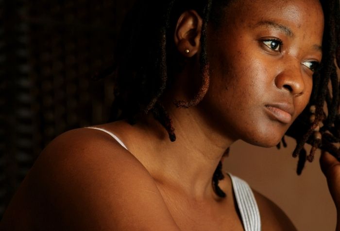 young black woman wearing white tank top looking away to the right