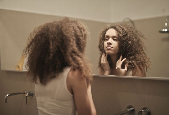 girl looking into mirror