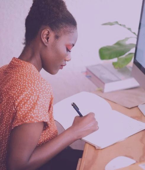 young african american women writing in a notebook